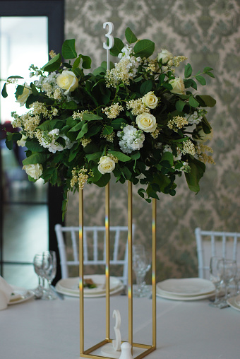 Hermosa flor blanca y verde decoración arreglo de boda mesa de soporte de oro. Decoración nupcial de la flor de la boda. photo