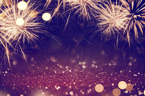 Gold and dark purple Fireworks and bokeh glitter in New Year eve and copy space. Abstract background holiday.