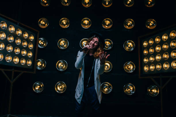 istock men singer with long hair, with microphone on the stage 969086812