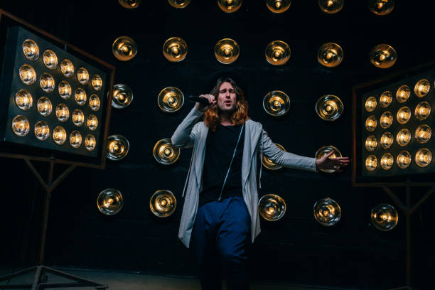 istock men singer with long hair, with microphone on the stage 969089152