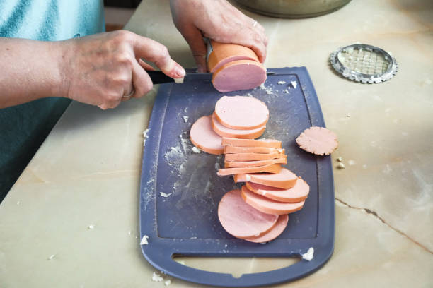 istock woman cutting a sausage 969096458
