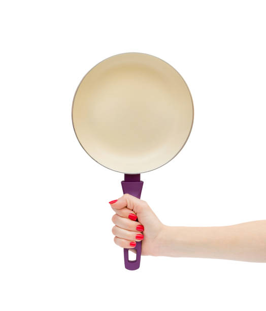 Woman's hand holding empty ceramic frying pan isolated on white.