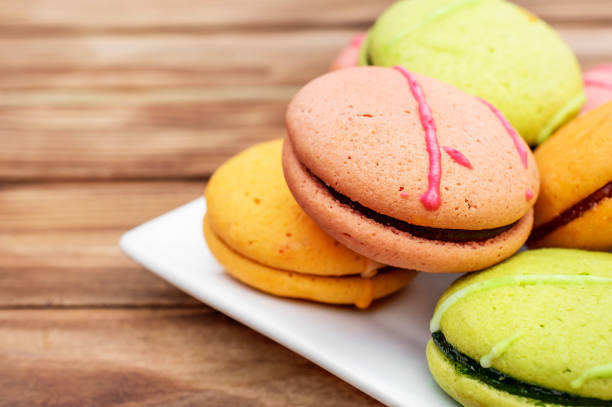 istock Plate with colorful macaroons on the wooden table. Close up. 969107700