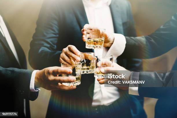 Hands Of Mans With Glasses Of Whiskey Celebrating And Toasting Stock Photo - Download Image Now