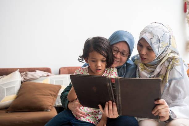 istock Three generations of women reading a book 969115582