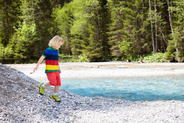 istock Child hiking in mountains. Kids at river shore. 969115878