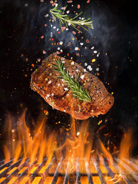istock Tasty beef steak flying above cast iron grate with fire flames 969118390