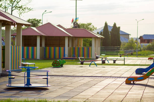 istock Beautiful new modern playground in kindergarten with soft pavement, bright new multicolored alcoves, swings, slides, benches, roundabout and sandbox. Perfect place for children activities outdoors. 969118856
