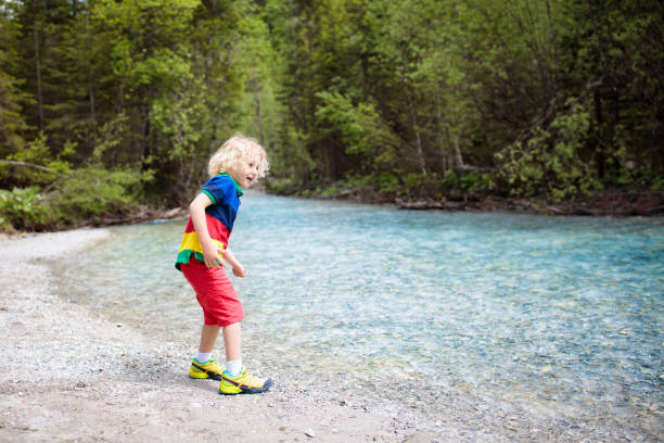 istock Child hiking in mountains. Kids at river shore. 969119016