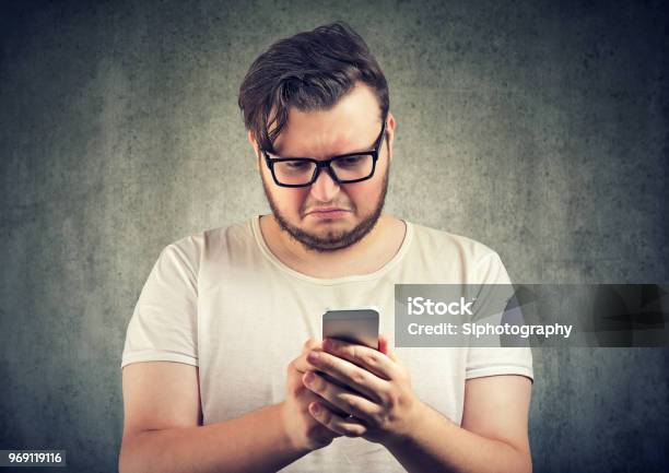 Upset Man Watching Smartphone Stock Photo - Download Image Now - Disgust, Men, Telephone