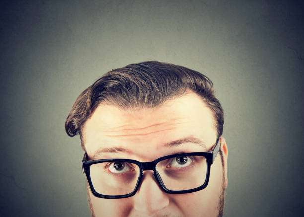 istock Doubtful man in glasses looking up 969119294