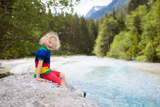 istock Child hiking in mountains. Kids at river shore. 969123256
