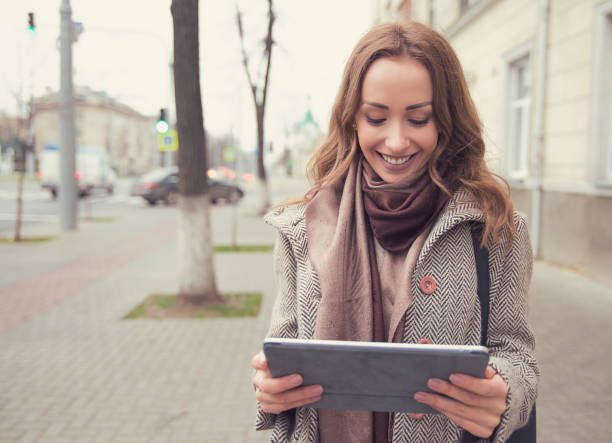 istock Happy woman watching tablet on street 969126088