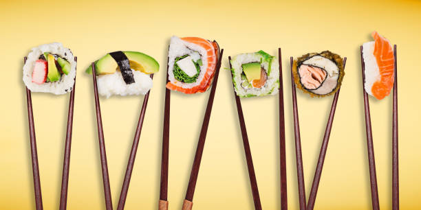 istock Traditional japanese sushi pieces placed between chopsticks, separated on light blue pastel background 969127086