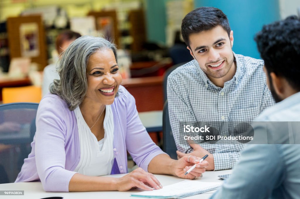 Senior manager facilitates staff meeting Confident African American senior businesswoman discusses something with colleagues during weekly meeting. Education Stock Photo