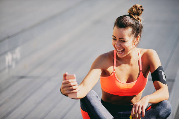 Woman sitting and taking selfie after exercising.
