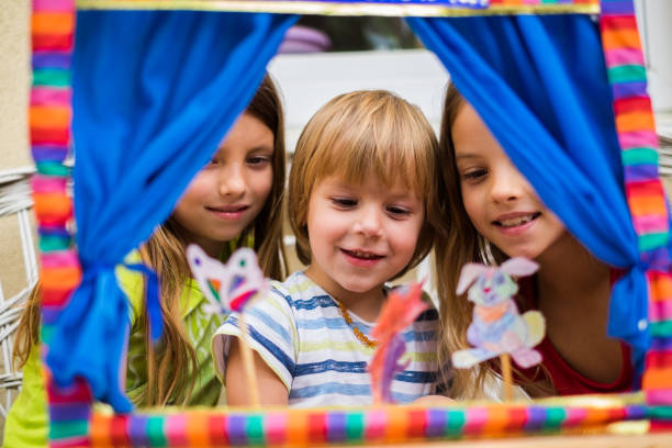 istock Sisters playing with brother puppet show 969153098