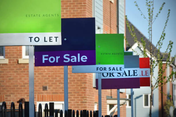Estate Agent signs Generic For Sale and To Let Estate Agent (Real Estate Agent) signs lined up outside a UK new build housing estate houses for sale stock pictures, royalty-free photos & images