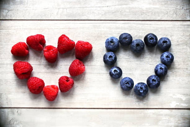 Berries: blueberries, raspberries  heart on a white wood background