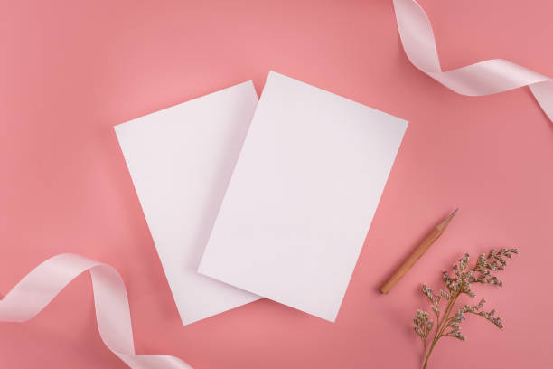 istock A wedding mock up concept. Wedding Invitation, envelopes, cards Papers on pink background with ribbon and decoration. Top view, flat lay, copy space 969234028