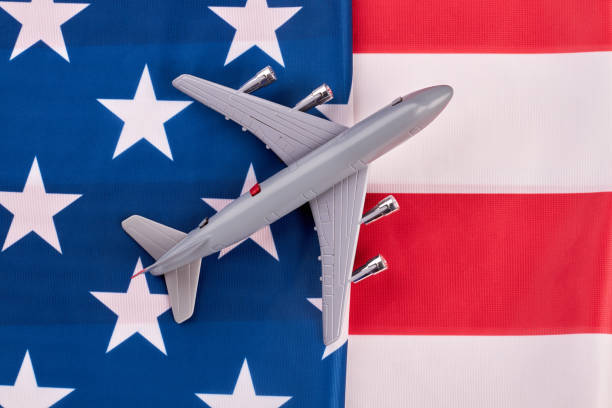 istock American flag background and grey toy air plane. 969234376