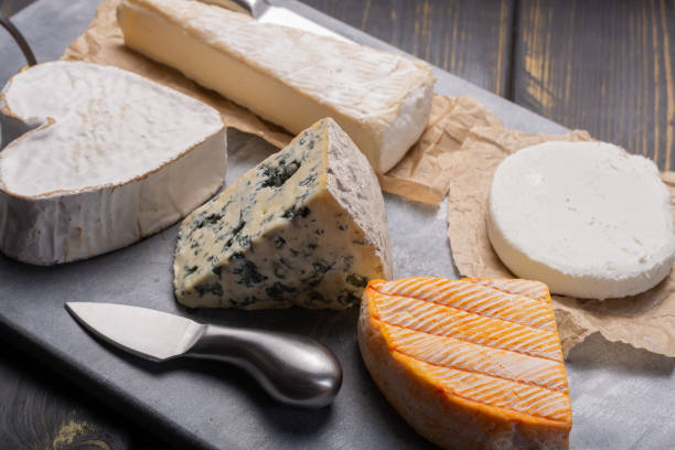 istock French cheeses plate in assortment, blue cheese, brie, munster, soft goat cheese, Neufchatel heart shaped cheese 969240412