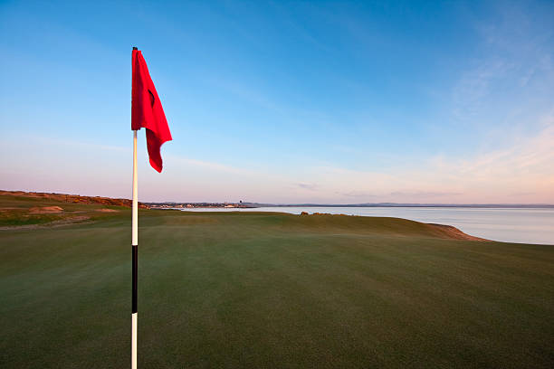 red drapeau de golf sur un green à l'aube - golf nobody flag dew photos et images de collection