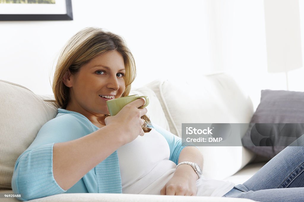 아름다운 젊은 여자 편안한 집에서요, 뜨거운 음료 - 로열티 프리 TV 보기 스톡 사진