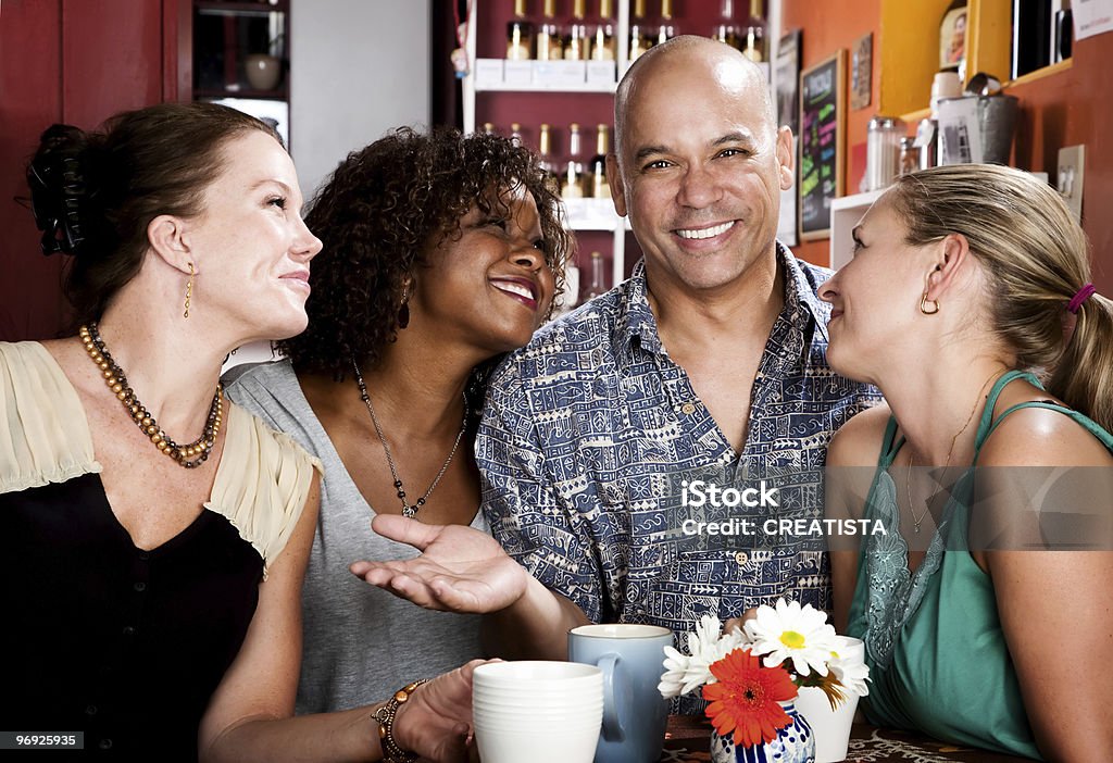 Uomo con tre graziosa donne nel coffee house - Foto stock royalty-free di Adulto