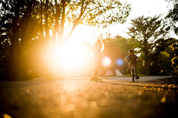 istock Mom and son racing while biking and skate boarding 969261860