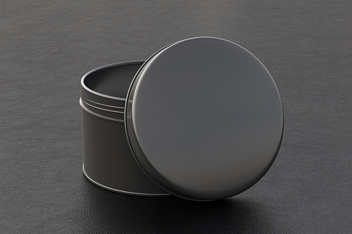 Blank black round tin container box with opened lid on black leather background. Package mockup with clipping path around container. 3d illustration
