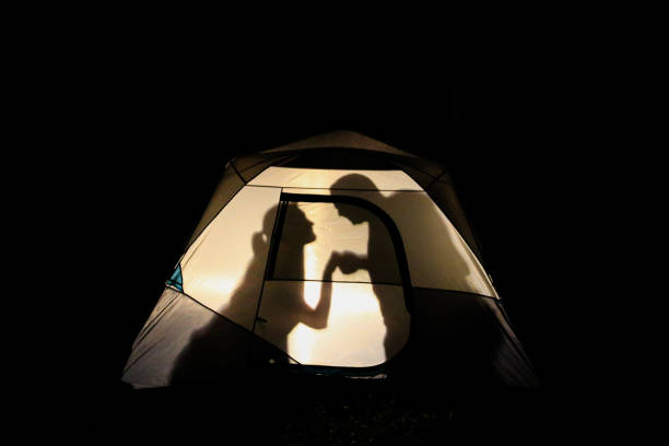 istock Male and Female Romance Vignettes inside Illuminated Camping Tent 969293844