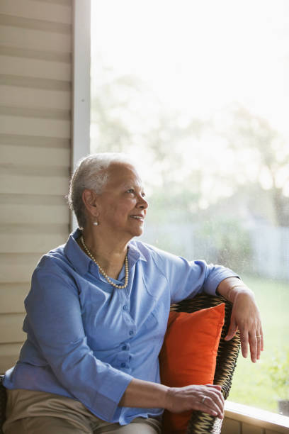 istock Senior Hispanic woman sitting on porch, looking content 969298094