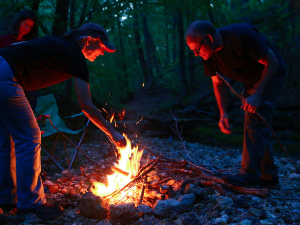 istock Teamwork Friends Camping Tending Building Campfire 969301370