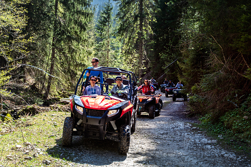 A tour group travels on ATVs and UTVs on the mountains.