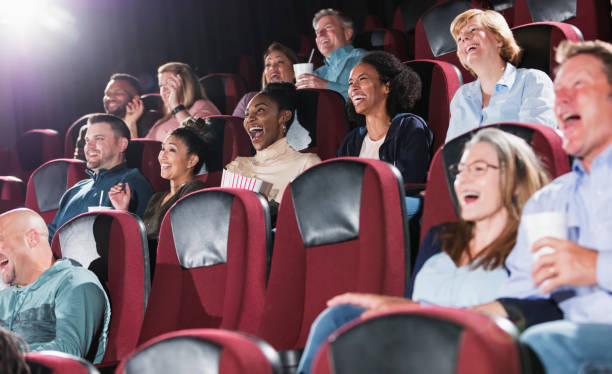 istock Multi-ethnic audience in a movie theater, laughing 969307230