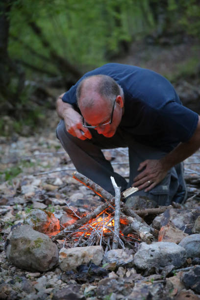 istock Man Building Camping Campfire on Stones 969309446