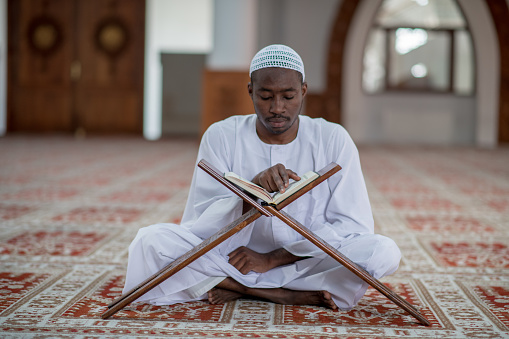 African Muslim Man Making Traditional Prayer To God While Wearing Dishdasha.