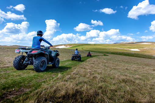 Friends driving off-road with quad bike or ATV and UTV vehicles.