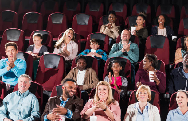 istock Multi-ethnic audience in movie theater, clapping 969314928