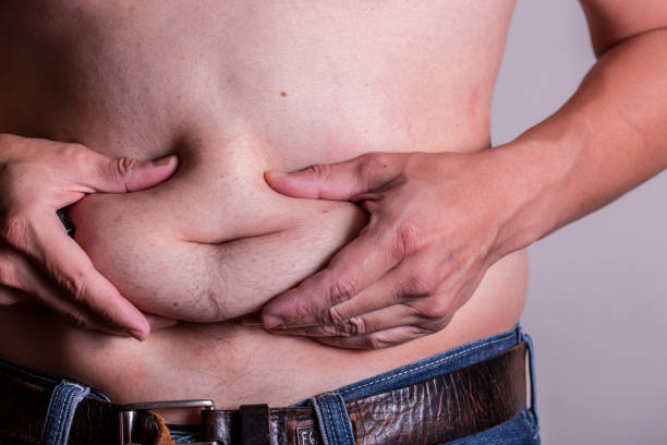 istock Man holding belly showing its BMI 969327654