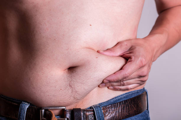 man holding belly showing its bmi - overweight men people abdomen imagens e fotografias de stock