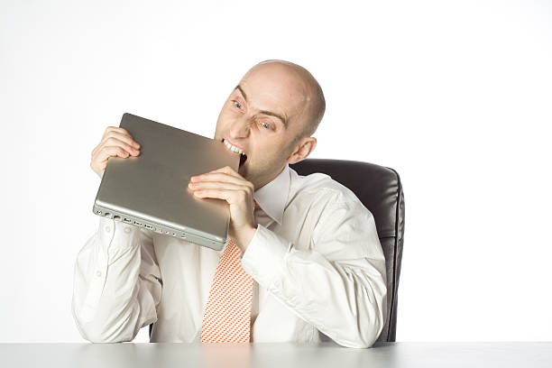Man Biting Laptop stock photo