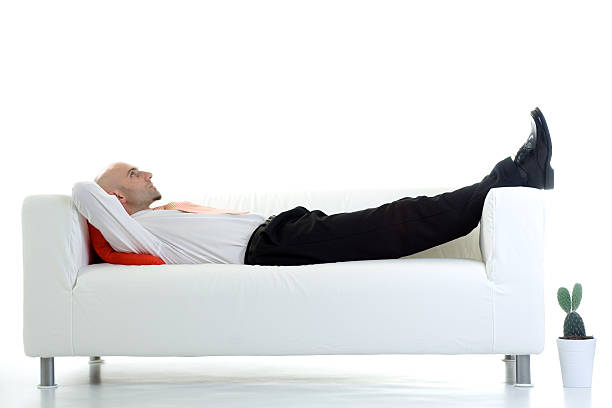 istock Adult male lying down on white couch 96934122