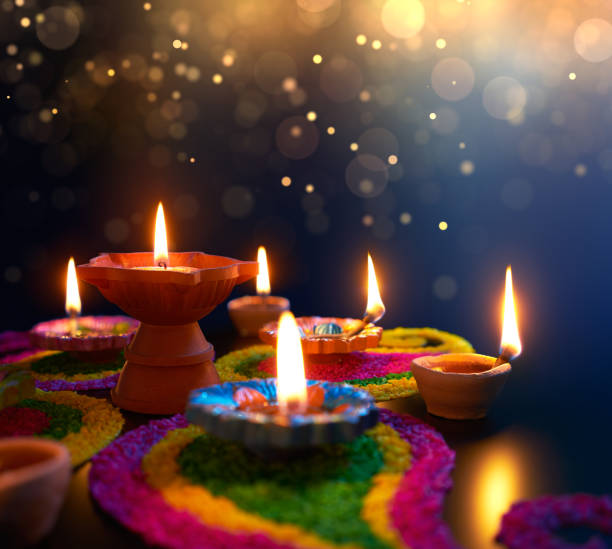 Diya lamps lit on colorful rangoli during diwali celebration Diya lamps lit on colorful rangoli during diwali celebration diwali photos stock pictures, royalty-free photos & images