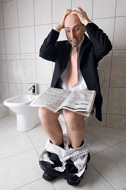 Man reading on toilet stock photo
