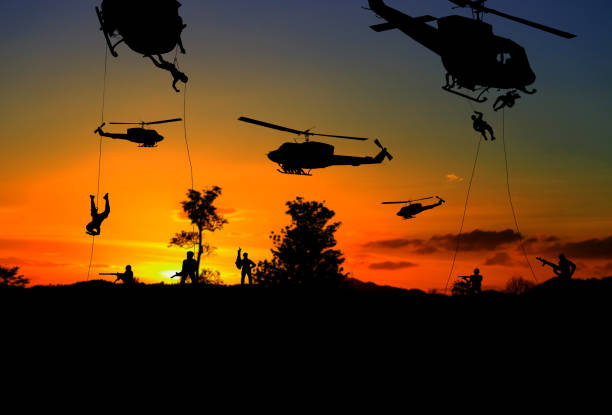istock Silhouette Soldiers rappel down to attack from helicopter with sunset and copy space add text ( Concept stop hostilities To peace) 969352954
