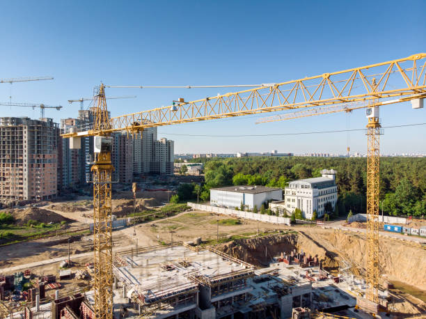 istock yellow building cranes on construction site against blue sky 969358140