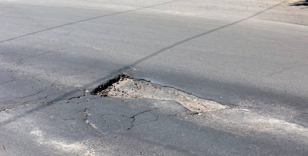 istock bad asphalt road, pit on the road 969360642