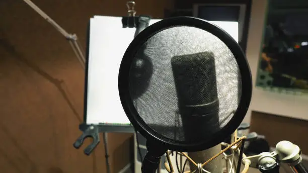 Microphone with pop filter and shock mount anti-vibration and note stand and tripod in music score studio production